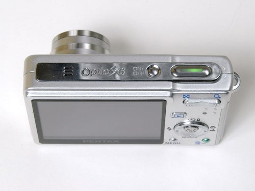 Pentax Optio S6 digital camera displayed on a white background, showcasing its large LCD screen, control buttons, and the stylish silver casing.
