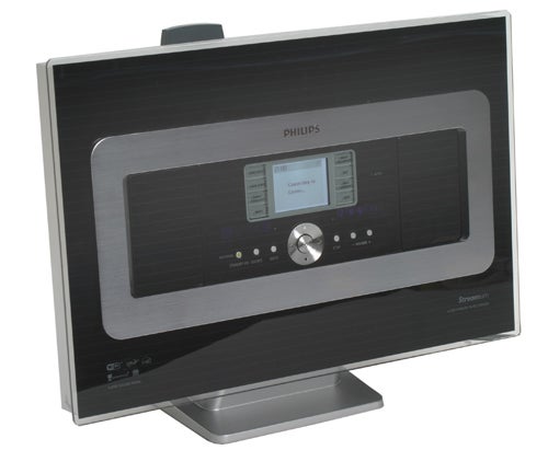 Philips WACS700/05 Wireless Music Station with display screen showing the user interface, touch-sensitive buttons, and a central dial, set on a steel stand against a white background.