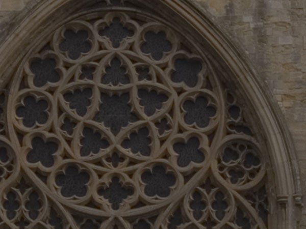 Close-up photo of the intricate stone lacework of a gothic rose window, showing detailed pattern designs, indicative of the Olympus E-500's ability to capture texture and architectural details under natural lighting conditions.