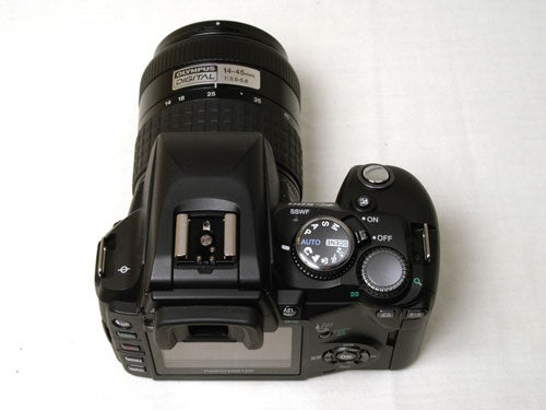 Olympus E-500 digital SLR camera with a 14-45mm lens attached, viewed from the top showcasing its control dials, shutter release button, and hot shoe mount.