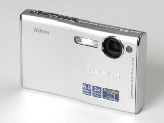 Nikon Coolpix S5 digital camera displayed on a white surface, showcasing its silver body, lens, and branding details.