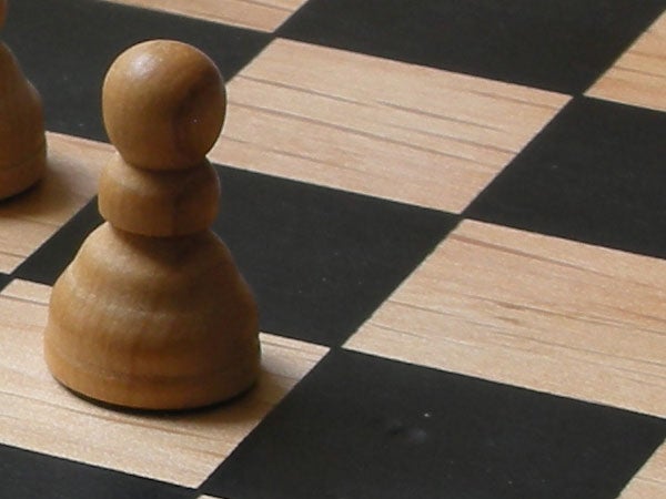 Close-up image of a wooden chess pawn on a chessboard showcasing the depth of field capability of the Nikon Coolpix S5 camera.