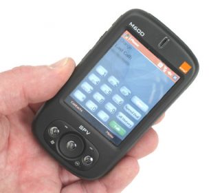 Hand holding an Orange SPV M600 smartphone displaying the home screen with menu icons.