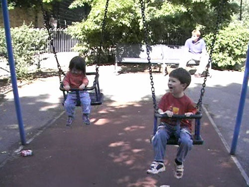 Video still of two children swinging on a playground, taken with a Panasonic VDR-D300 camcorder, demonstrating the camera's video quality in daylight.