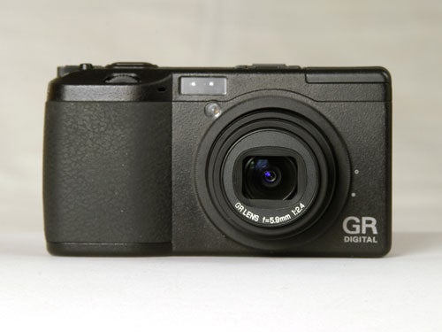Black Ricoh GR Digital camera with lens retracted on a neutral background.