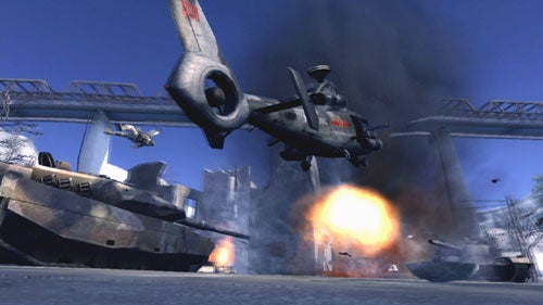 Screenshot from the video game Battlefield 2: Modern Combat showing a combat scene with an explosion and military vehicles including a helicopter and a tank.