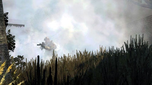 A soldier in camouflage maneuvers through smoke on a virtual battlefield with buildings in the background in a screenshot from the video game Battlefield 2: Modern Combat.