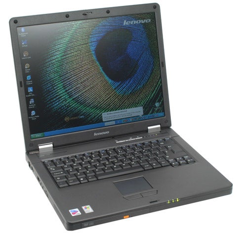 Lenovo 3000 C100 laptop open and powered on displaying desktop wallpaper with Lenovo logo, resting on a plain surface.