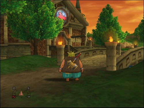 Screenshot from the video game Dragon Quest: The Journey of the Cursed King showing a character in medieval attire standing before a stone bridge with lit torches, leading to a building adorned with a circular stained glass window under an orange twilight sky. A compass on the screen shows east, south, and west directions.