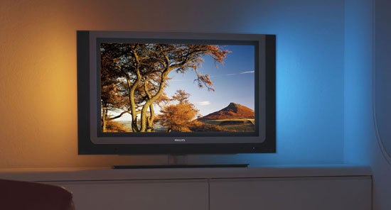 Philips 37PF9830 37-inch LCD TV displayed in a dimly lit room with ambient blue backlighting, showing vibrant colors on screen with a nature image.