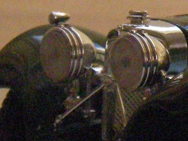 Close-up of vintage-style motorcycle headlights with a focus on the metal casings and detailed design.
