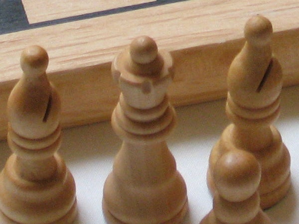Close-up photo of wooden chess pieces on a chessboard, showcasing the clarity and depth of field achievable with the Canon PowerShot A540 camera.