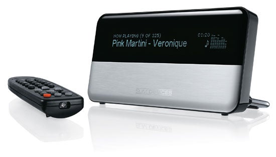 Slim Devices Squeezebox digital music player with a reflective silver finish and black screen displaying the song "Pink Martini - Veronique", alongside its remote control.