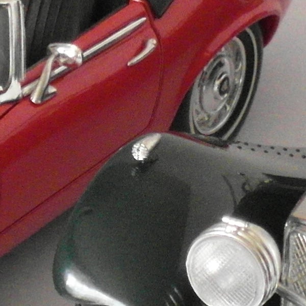 Close-up of a vintage red car's front detail