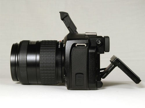 Olympus E-330 digital SLR camera with lens attached, displayed on a neutral background, showing its left side with flip-out LCD screen open.