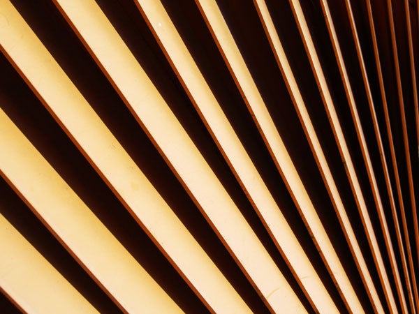 Diagonal pattern of shadows and light cast through a series of parallel slats, showcasing the camera's ability to capture contrast and detail.