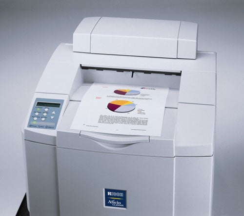 Ricoh Aficio CL1000 Colour Laser Printer with an output tray containing a printed page with colorful pie charts and text.