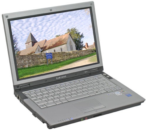 Samsung Q35 ultra-portable notebook open on a desk displaying a wallpaper of a rustic church and countryside.