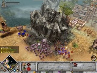 Screenshot of gameplay from Rise and Fall: Civilizations at War showing a battle scene with various military units engaged near water and a rocky outcrop, with in-game interface visible.