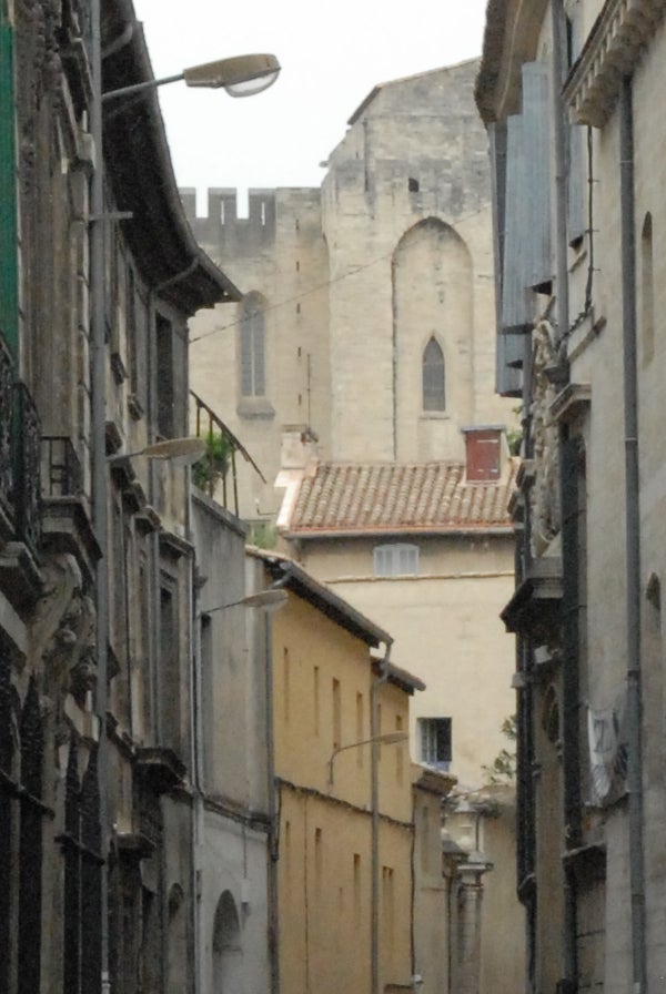 Photograph showcasing the image quality of the Nikon D200 Digital SLR camera, featuring a narrow European street lined with historic buildings leading to a large stone structure with battlements.