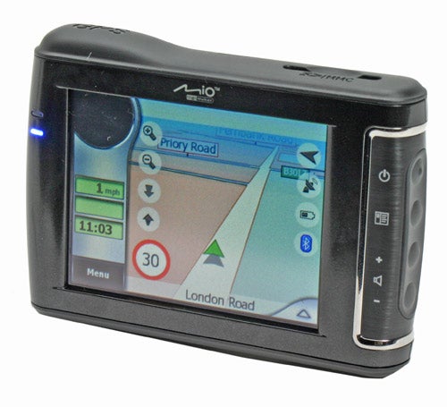 Mio DigiWalker C710 portable GPS navigator device with the screen displaying a map and driving information including speed and time.