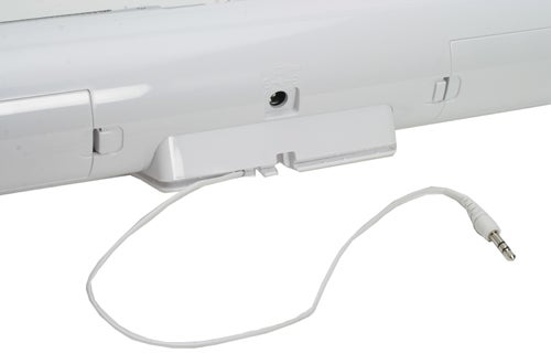 White Logitech mm32 portable speaker dock connected to a device with a standard 3.5mm audio plug.