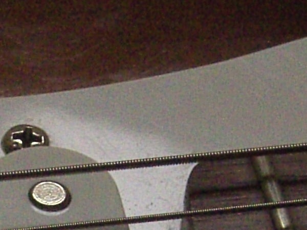 Close-up view of a guitar's curvature, focusing on the strings and the sound hole, captured with an Acer CP-8660 Digital Camera.