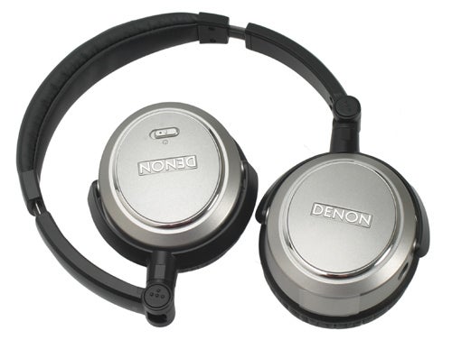 Denon brand headphones with silver earcups and black padding, displaying the Denon logo.