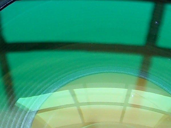 Unfocused photograph of a green circular object with reflection, possibly demonstrating image quality issue with Casio Exilim EX-Z1000 Compact Digital Camera.