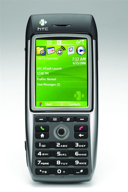 Product image showing the HTC MTeoR Windows Mobile 3G Smartphone with its screen displaying the home interface, featuring icons for various applications and services, and the phone's keypad visible below.