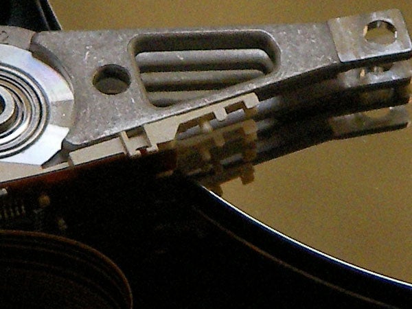 Close-up view of a hard drive read-write head over a platter, representing data storage technology which might be similar to the kind used in the Sanyo Xacti VPC-HD1 digital camcorder.