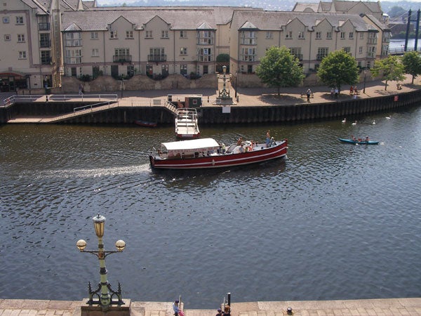 View of a river with boats and waterfront buildings possibly captured with a Sanyo Xacti VPC-HD1 camcorder.