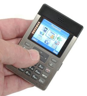 A person holding the Samsung SGH-P300 Super Slim Mobile Phone showcasing its main screen with menu icons.