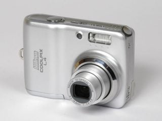 Nikon Coolpix L4 digital camera displayed on a plain background, showing the lens extended and the front panel with model inscription.