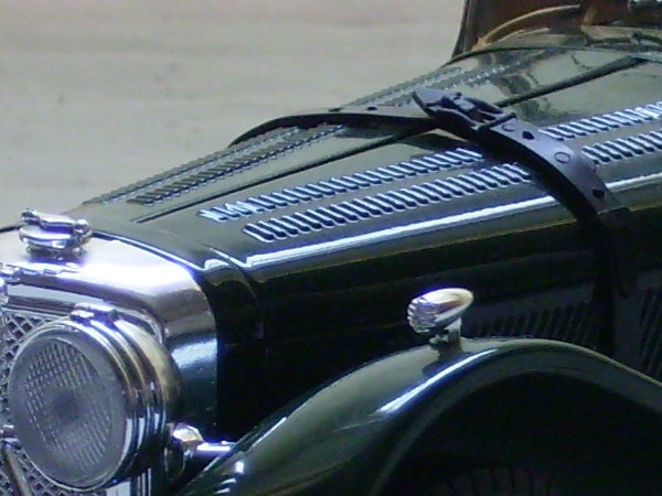Close-up photograph of a vintage car's hood and grille taken with the Olympus FE-150 digital camera.