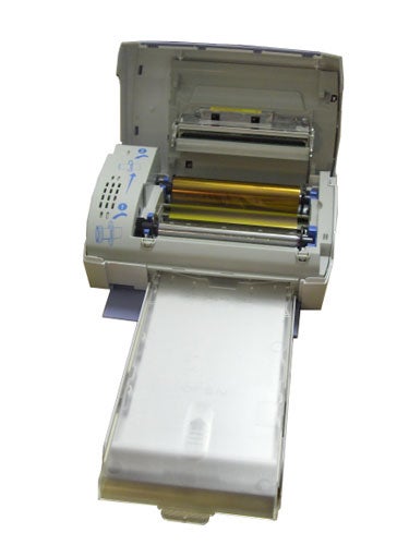 Sagem PrintEasy 110 photo printer with open cover showing paper tray and internal printing mechanism.