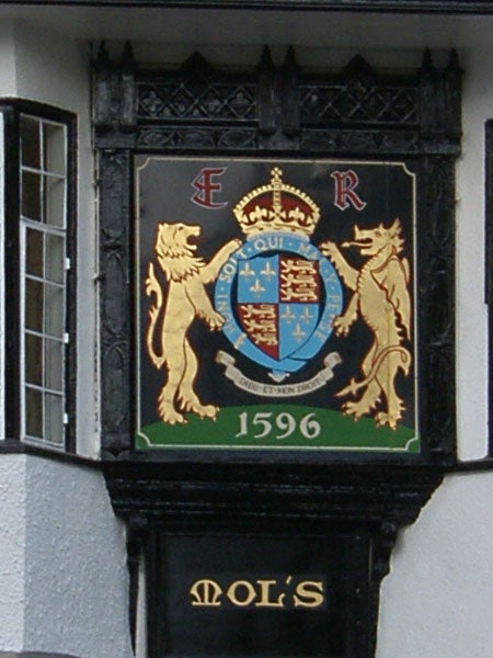 Royal coat of arms sign with the date 1596 on a building.