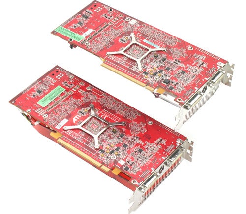Two ATI Radeon X1950 XT-X graphics cards lying side by side with red circuit boards and silver cooling units.