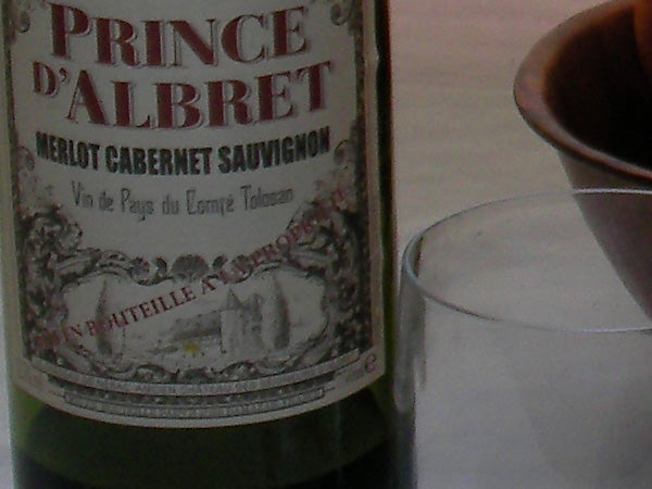 Close-up of a Prince d'Albret Merlot Cabernet Sauvignon wine bottle with a blurry background.