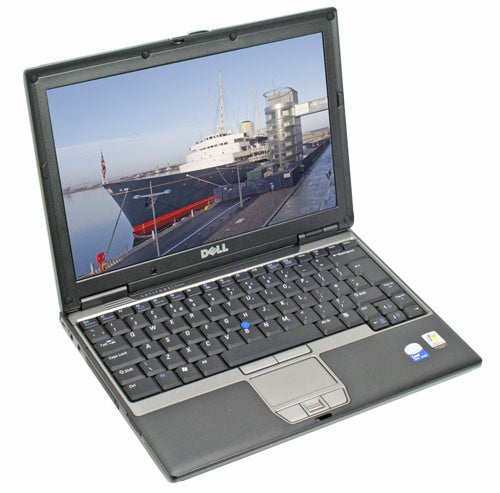 Dell Latitude D420 laptop with open lid showing a screen displaying a boat at a dock, set against a black keyboard and trackpad, with Dell logo visible on the back of the screen.