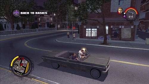 Screenshot from the video game Saints Row showing gameplay with two characters driving an old convertible car at night on a city street. The game's HUD is visible, displaying the mission title 