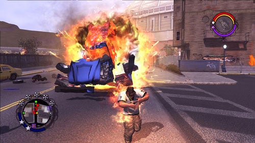 A scene from the Saints Row video game showing a character witnessing an explosive car wreck in the middle of a street, with game HUD elements visible on-screen.