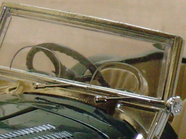 Vintage car reflection in chrome mirror housing.