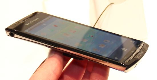 The image shows a person holding a Sony Xperia smartphone angled to display its side profile.