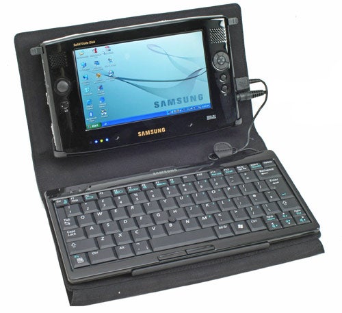 Samsung Q1 Ultra Mobile PC with extended keyboard accessory displayed on a flat surface, powered on and showing desktop screen.
