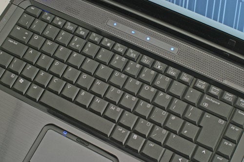 Close-up view of the keyboard and touchpad area on an HP Compaq Presario V6000 laptop, showcasing the layout and design of the keys and touch-sensitive controls.