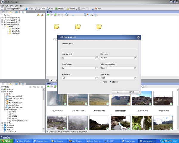 Screenshot of Roxio Easy Media Creator 9 software open on a computer desktop, showing the 'Cell Phone Settings' dialog box with options for photo and video size, video file type, and audio format, against a backdrop of other open windows displaying media files.