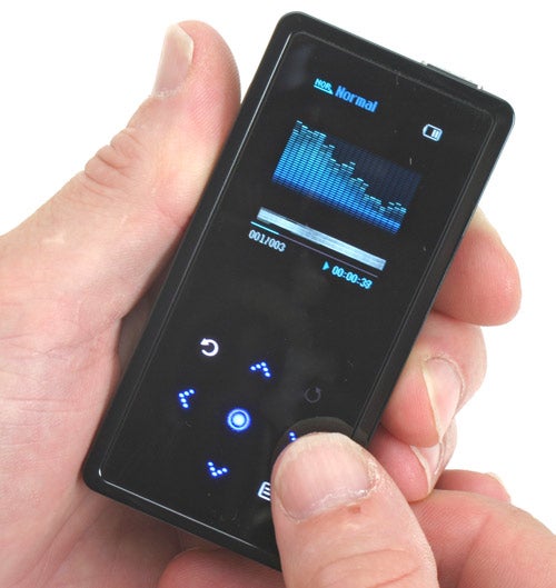 A hand holding a Samsung YP-K5 MP3 player with its touchscreen display lit up, showing a graphical equalizer and playback controls.