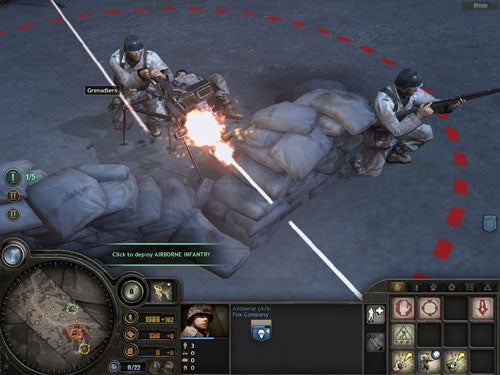 Screenshot from the "Company of Heroes" video game showing a combat scene with soldiers behind sandbags, one firing a machine gun, with the game's user interface including a minimap, unit information, and ability icons visible.