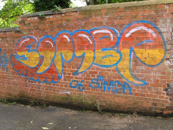 Graffiti art on a brick wall showcasing vibrant blue and orange letters with the word 